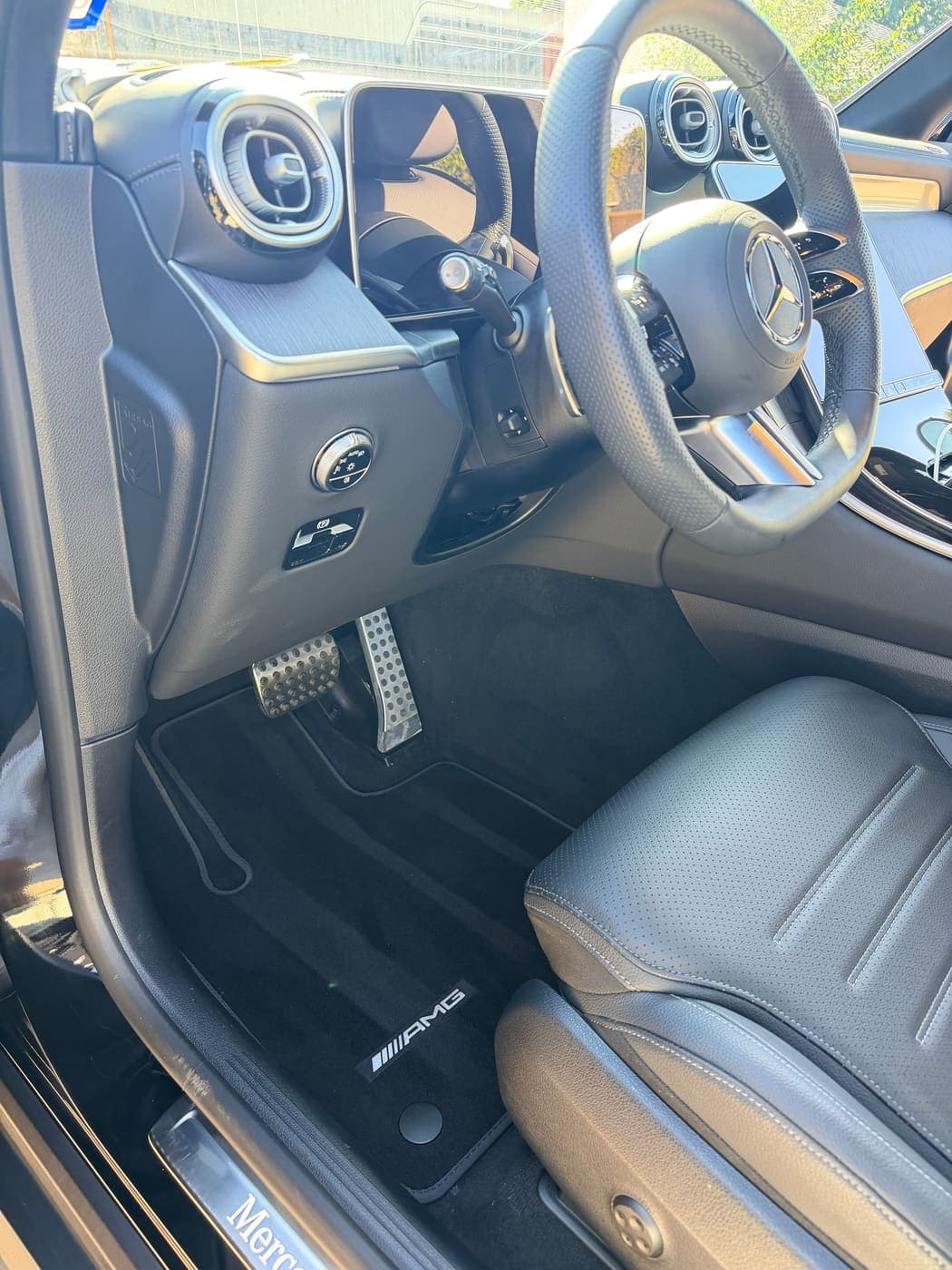 Clean Mercedes-Benz driver seat, steering wheel and AMG floor mat