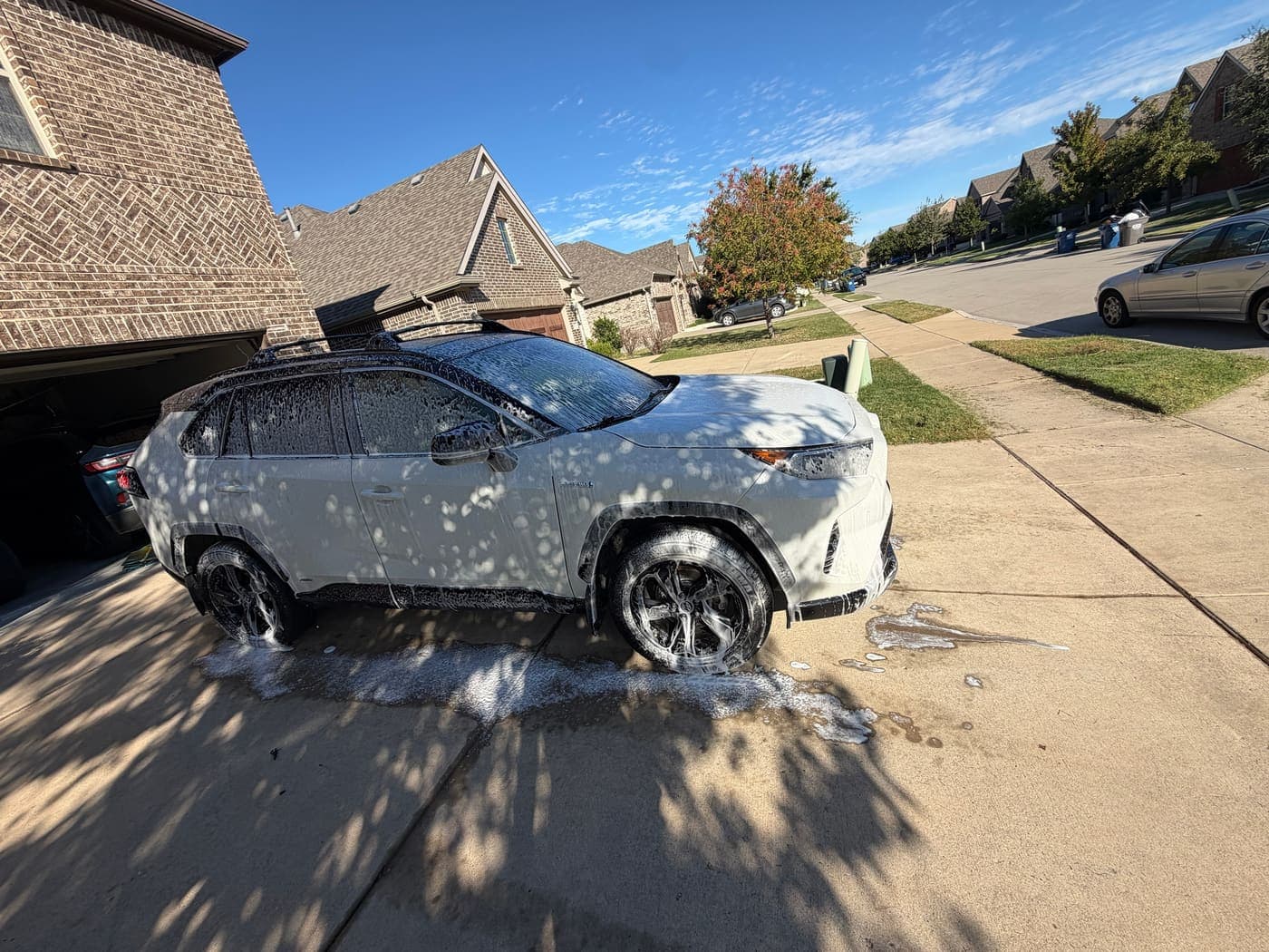 Toyota RAV4 being rinsed in a driveway during a mobile wash