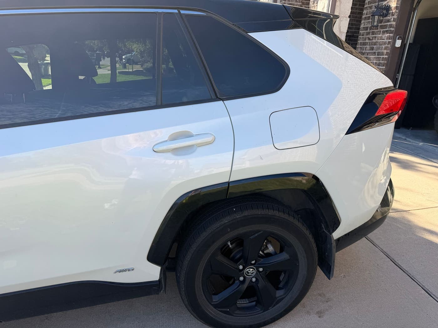 Side of a white Toyota RAV4 after washing, showing clean paint and wheel